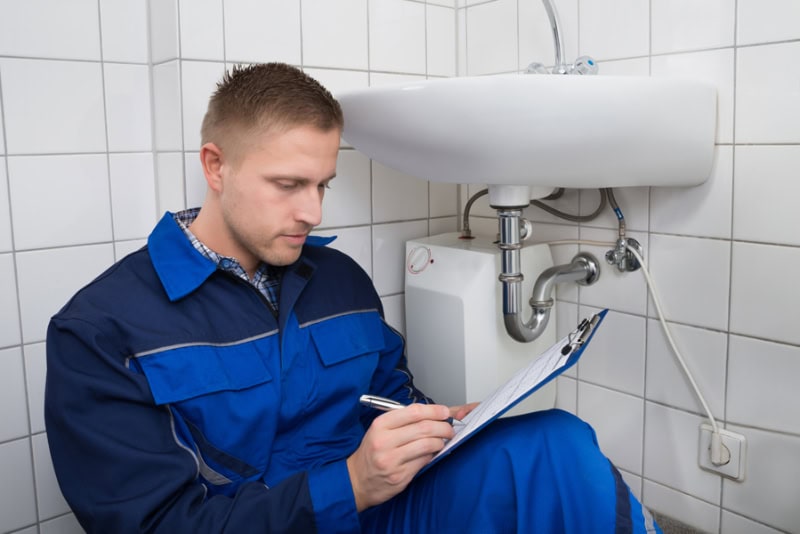 Expert plumber running through a plumbing inspection in bathroom off San Diego, California home.