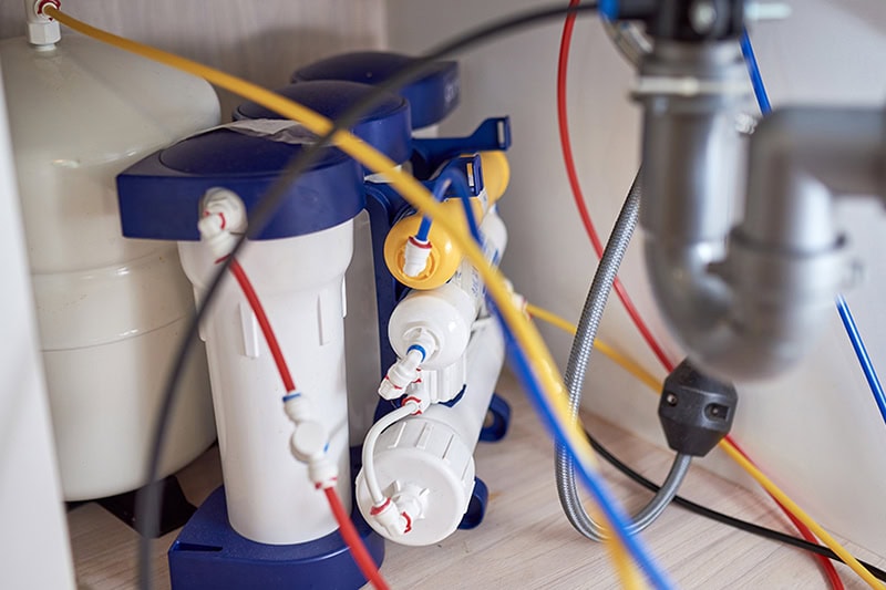 What Is Reverse Osmosis? Photo of water filtration system installed under a sink.