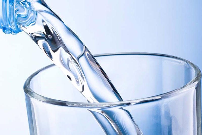 Water pouring into glass cup.